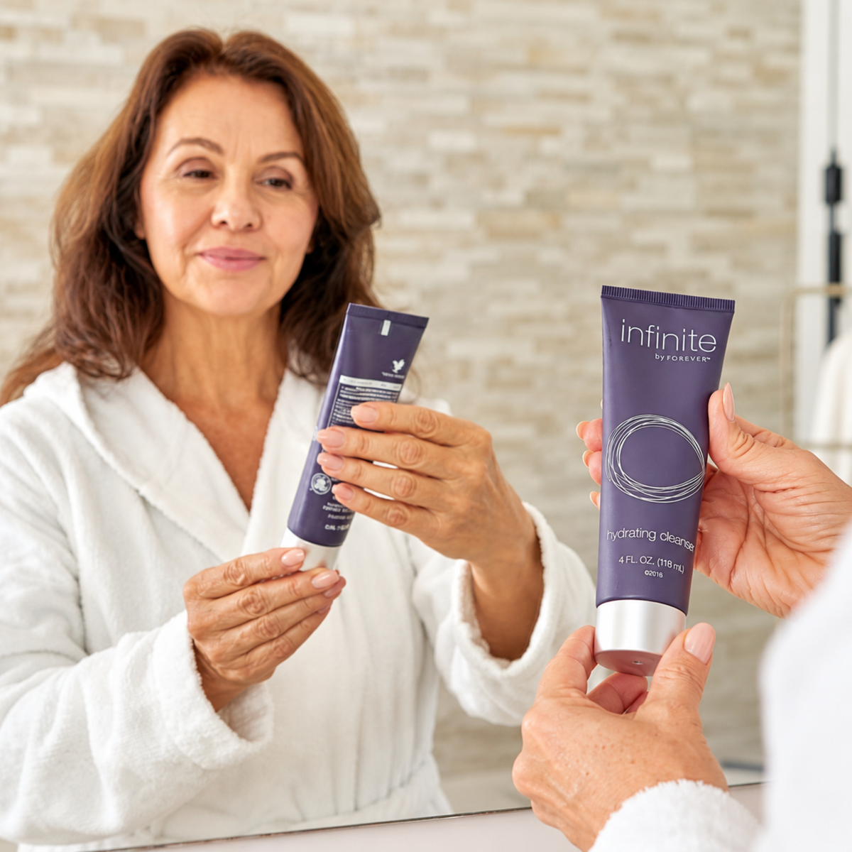 Femme tenant le Démaquillant Hydratant Infinite Forever devant un miroir lors de sa routine quotidienne de soin du visage