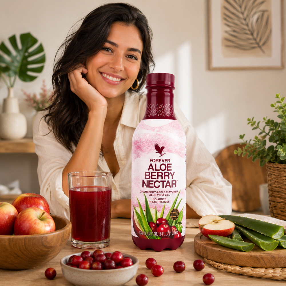 Femme souriante dégustant Forever Aloe Berry Nectar 1 L dans un intérieur moderne avec verre de boisson et bouteille officielle