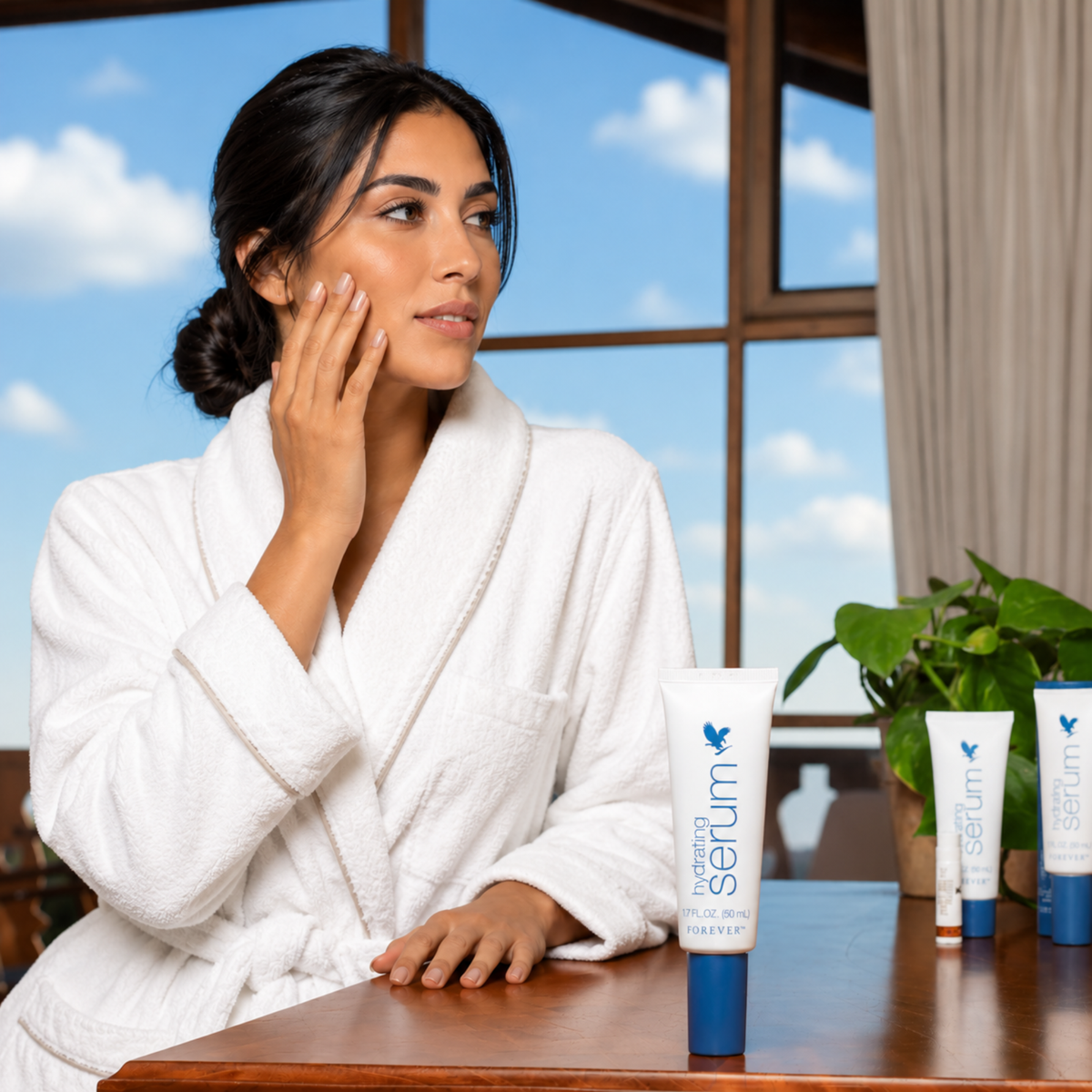 Femme maghrébine en peignoir appliquant le Forever Hydrating Serum pour une routine de soin hydratante du visage.