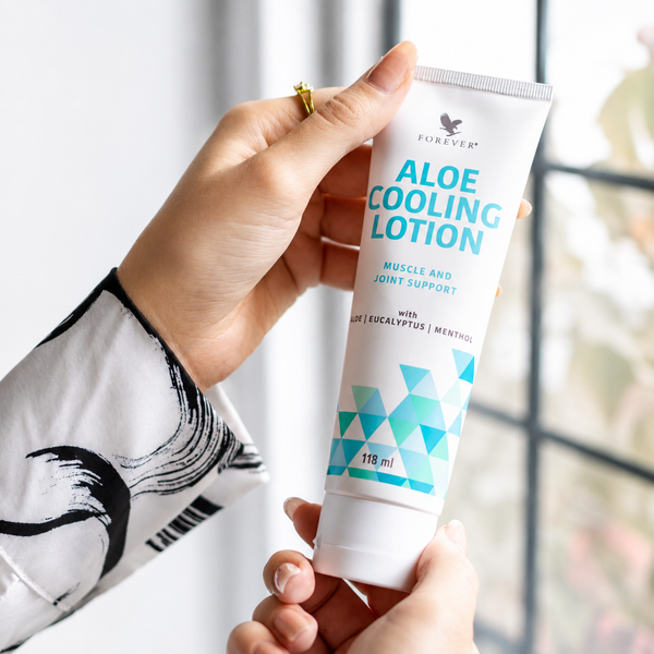 Main tenant un tube de Forever Aloe Cooling Lotion 118 ml prêt à l'utilisation