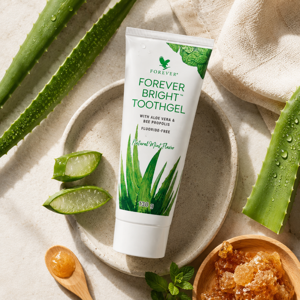 Forever Bright Toothgel entouré de feuilles d'Aloe Vera fraîches et de propolis, illustration de sa composition naturelle