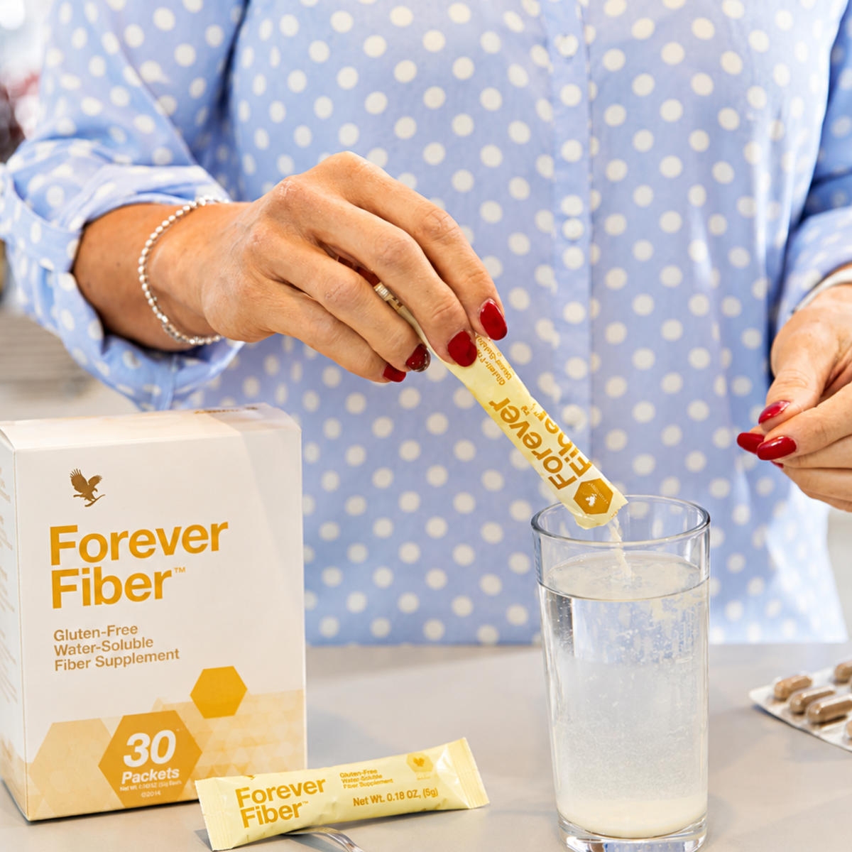 Forever Fiber™ en sachet versé dans un verre d'eau pour une utilisation quotidienne