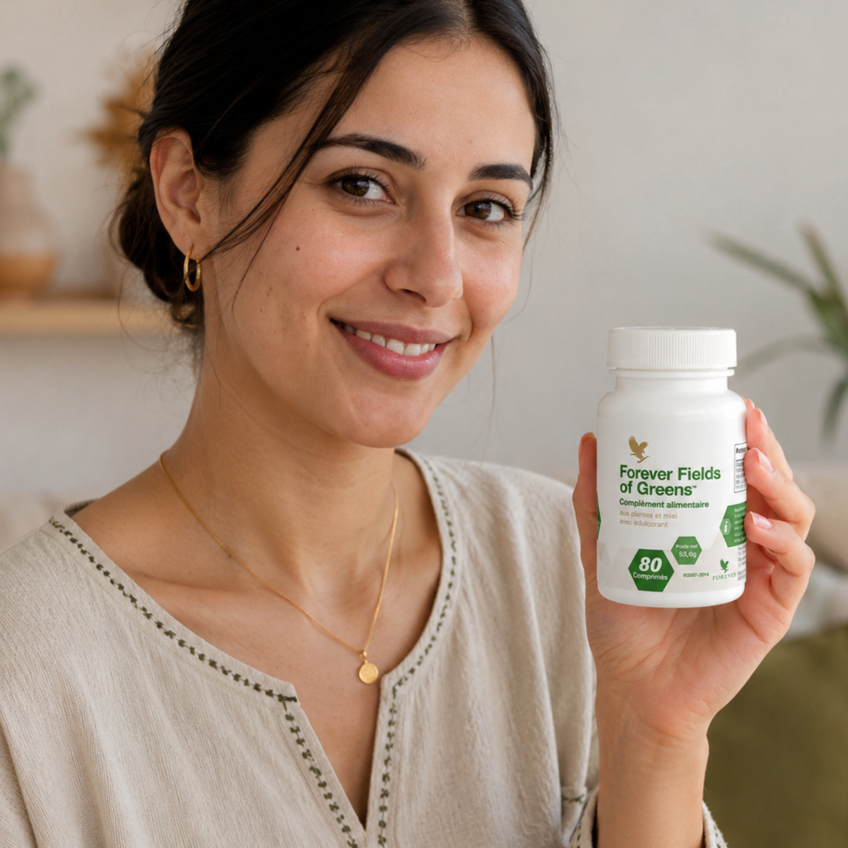 Femme marocaine tenant un flacon de Forever Fields of Greens™ dans un intérieur lumineux